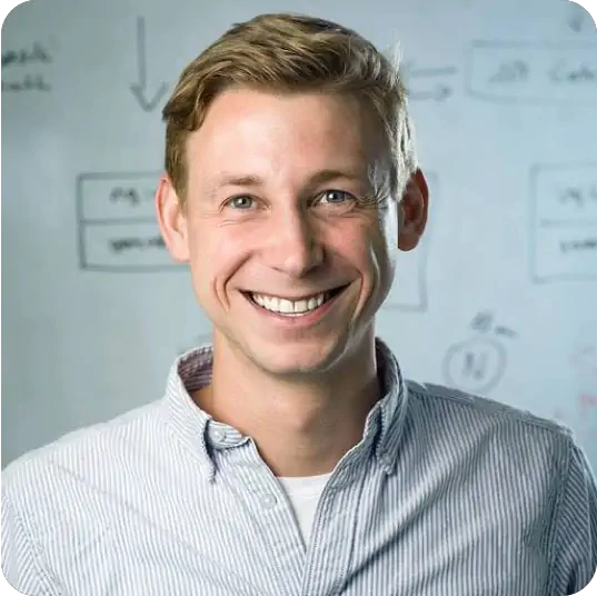 A man with blonde hair smiling at the camera.