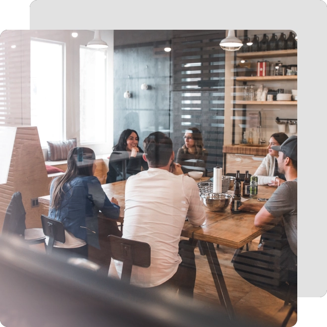 A group of people sitting around a wooden table.